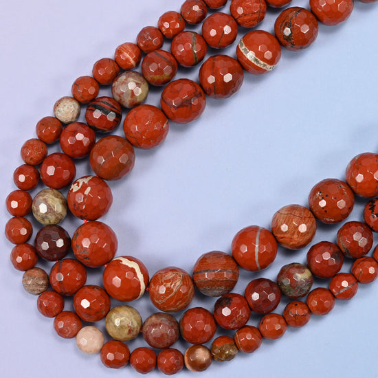 Macro detail of flower red jasper bead surface, highlighting the faceted texture and shine.