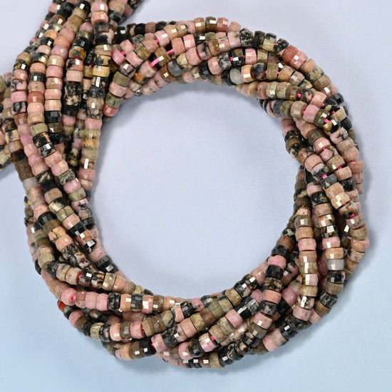 Rhodonite faceted heishi disc beads coiled into overlapping loops, whole strands of pink and black stone