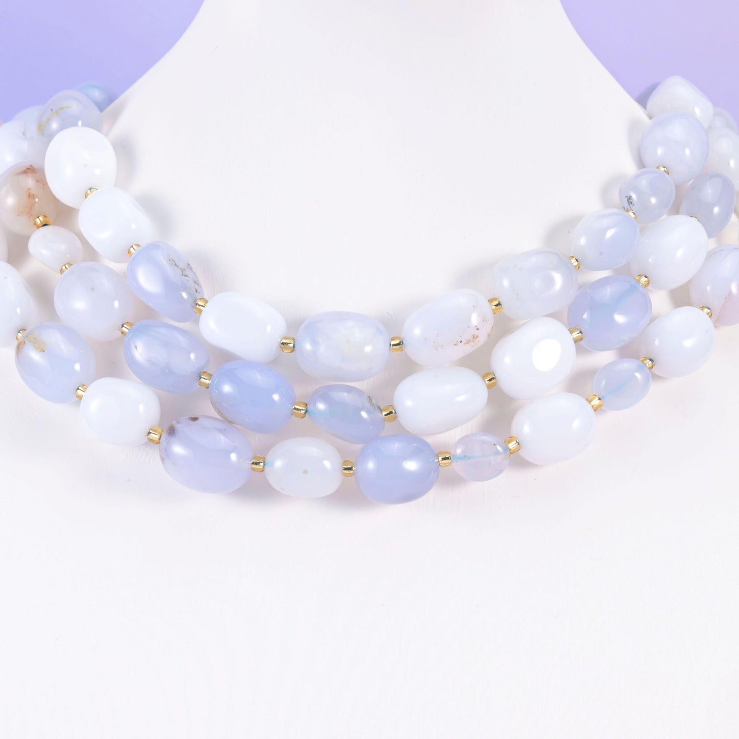 Soft blue and white chalcedony ovals styled on a white neck form, gold spacers between beads