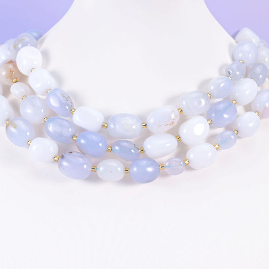 Soft blue and white chalcedony ovals styled on a white neck form, gold spacers between beads