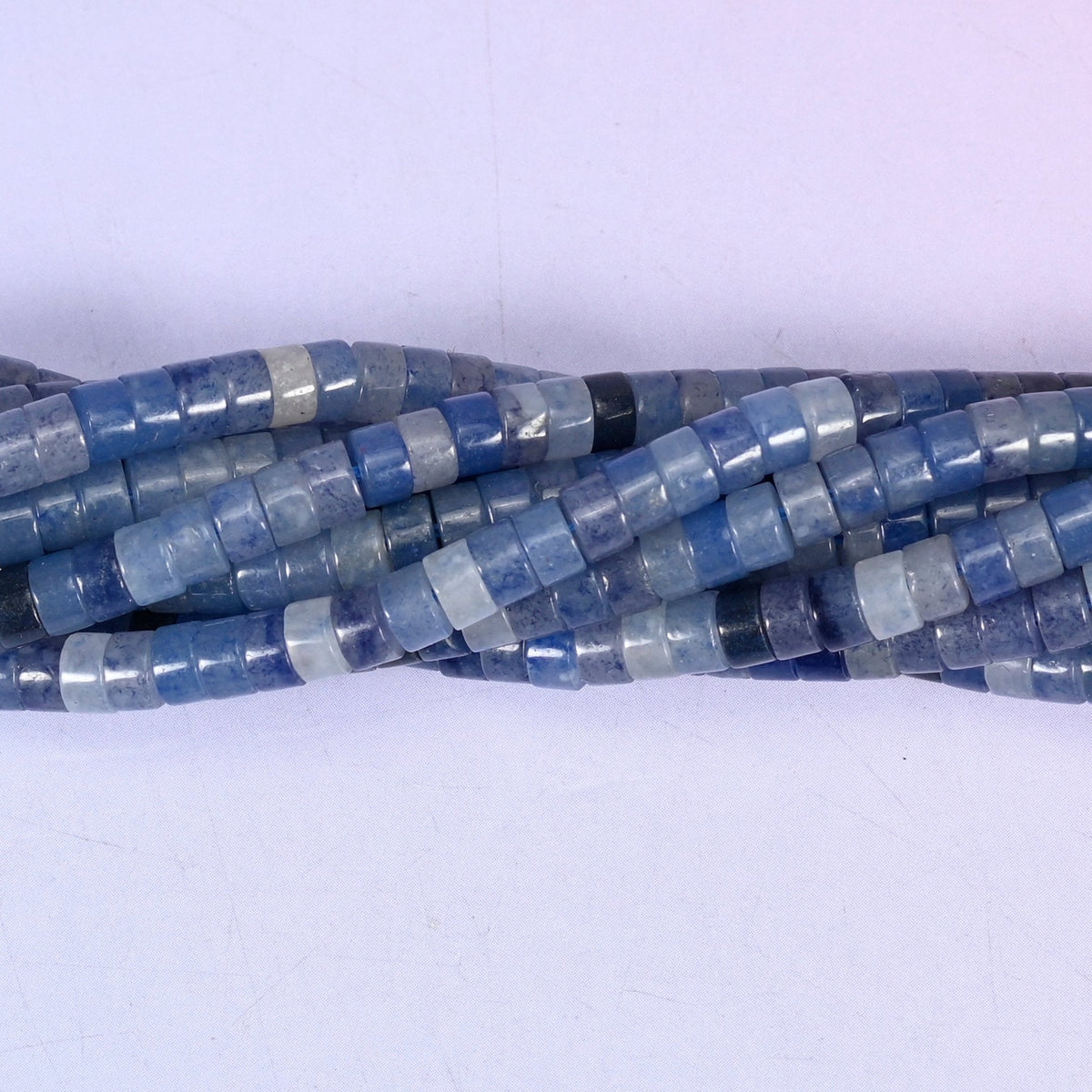 Natural Blue Aventurine smooth heishi disc beads in shades of soft powder blue to deep navy, finished with a polished, sophisticated look.