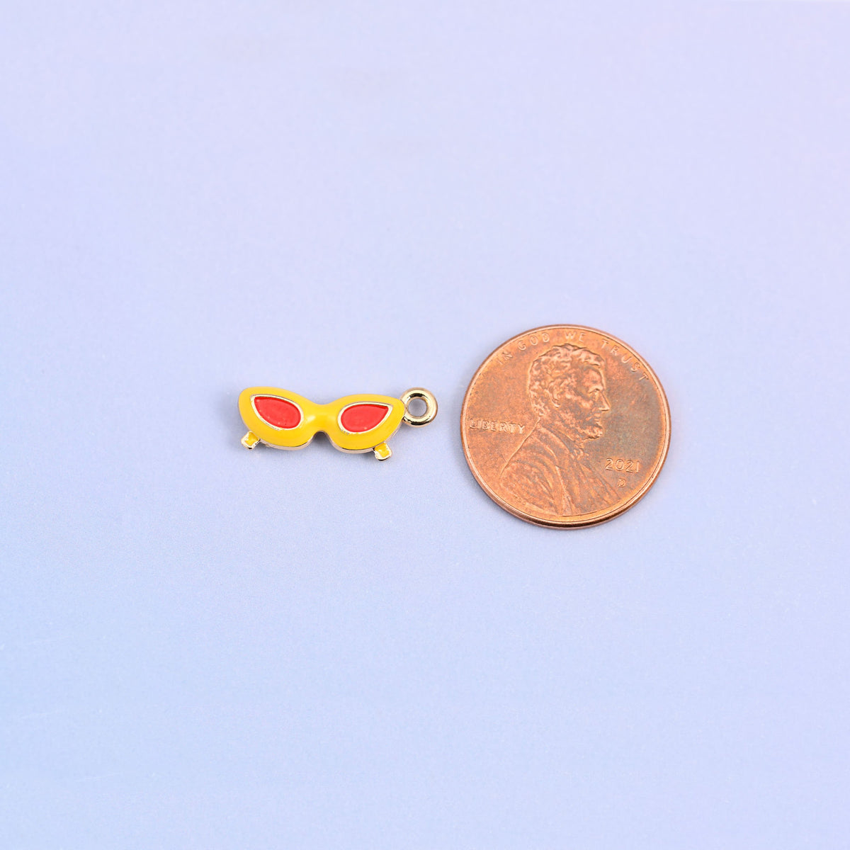 Yellow and red sunglasses charm shown at actual size, 18.02 x 6.84mm.