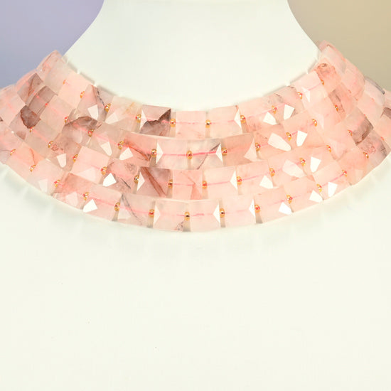 Natural red hematoid quartz faceted flat square strands arranged as a layered collar on a white display bust, light pink beads across the neck