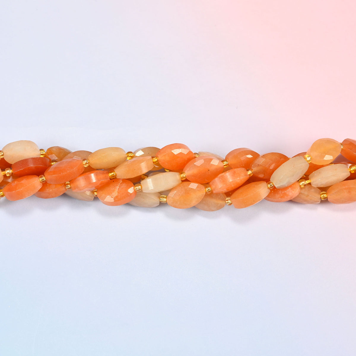 Strands of red aventurine faceted flat oval beads twisted together in a horizontal row