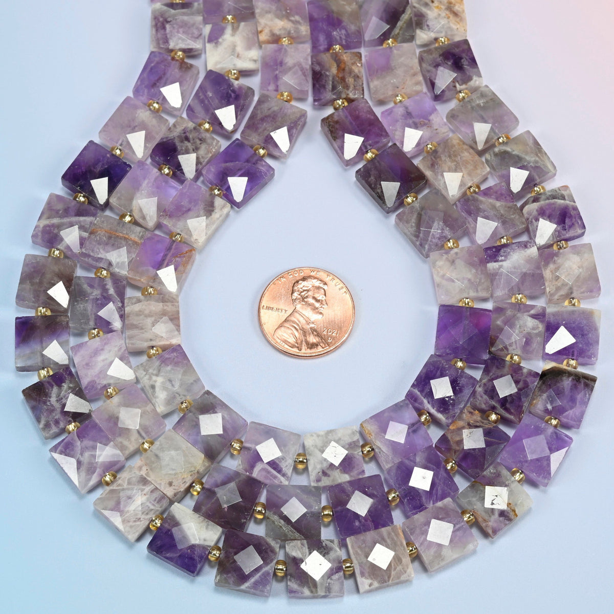 Natural amethyst faceted flat square strands formed into a teardrop loop around a US penny for scale
