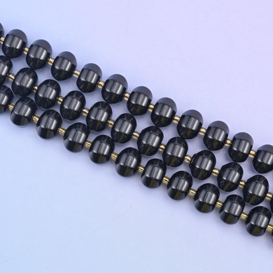 Angled run of 12x8mm obsidian pumpkin rondelles across pale lilac, gold seed beads between each stone