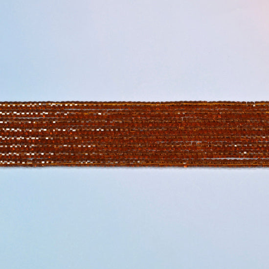 Several strands of brown glass faceted heishi disc beads laid in straight rows