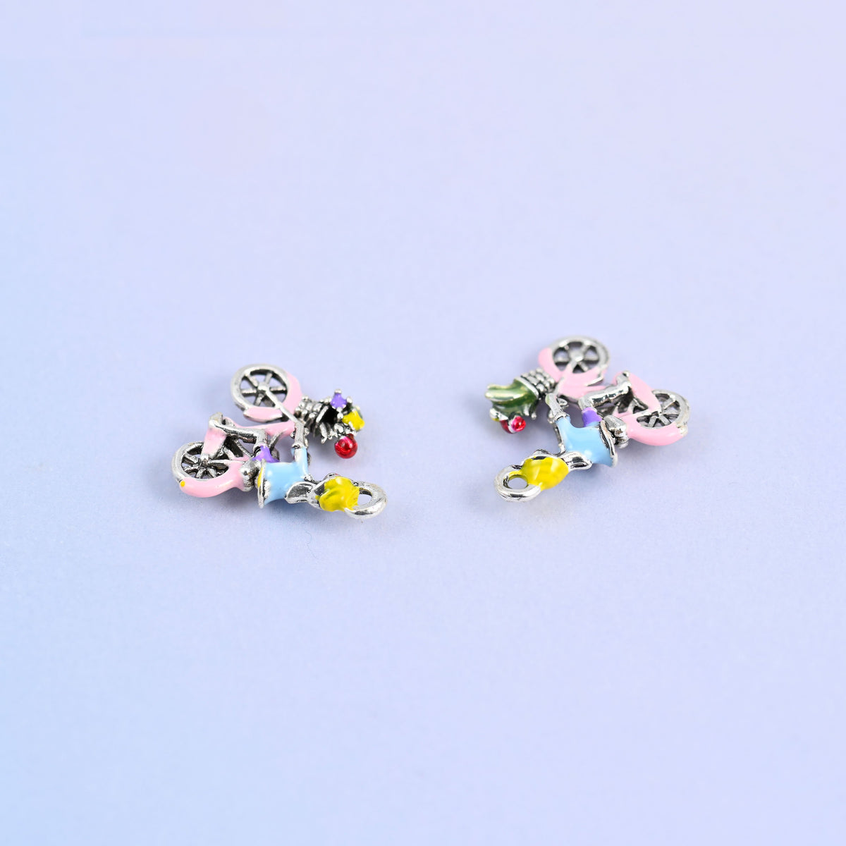 Two bicycle charms angled on their sides, approximately 4.41mm thick.
