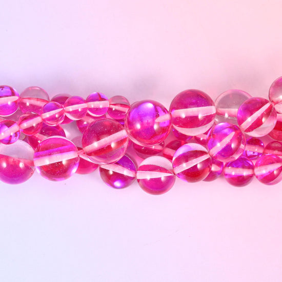 Transparent raspberry-pink glass beads finished with an iridescent aura coating