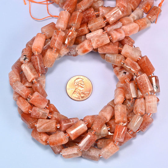 Close-up of faceted Golden Strawberry Quartz tube beads with clear glass spacer beads on a lavender background.