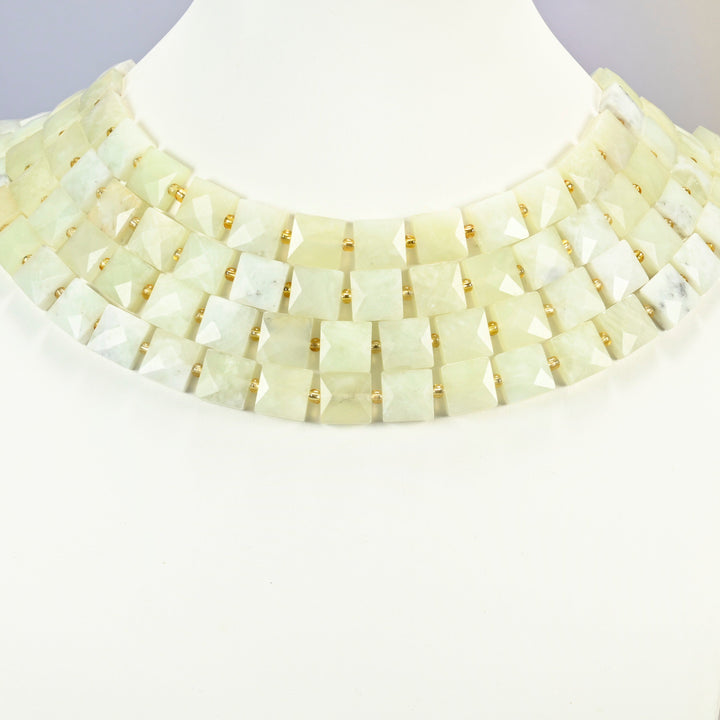 New Jade faceted flat square strands arranged as a layered collar on a white display bust, light yellow-green beads across the neck