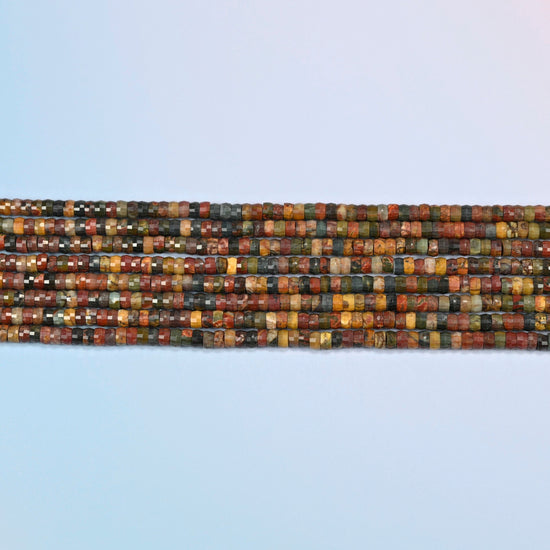 Several strands of red howlite faceted heishi disc beads laid in straight rows
