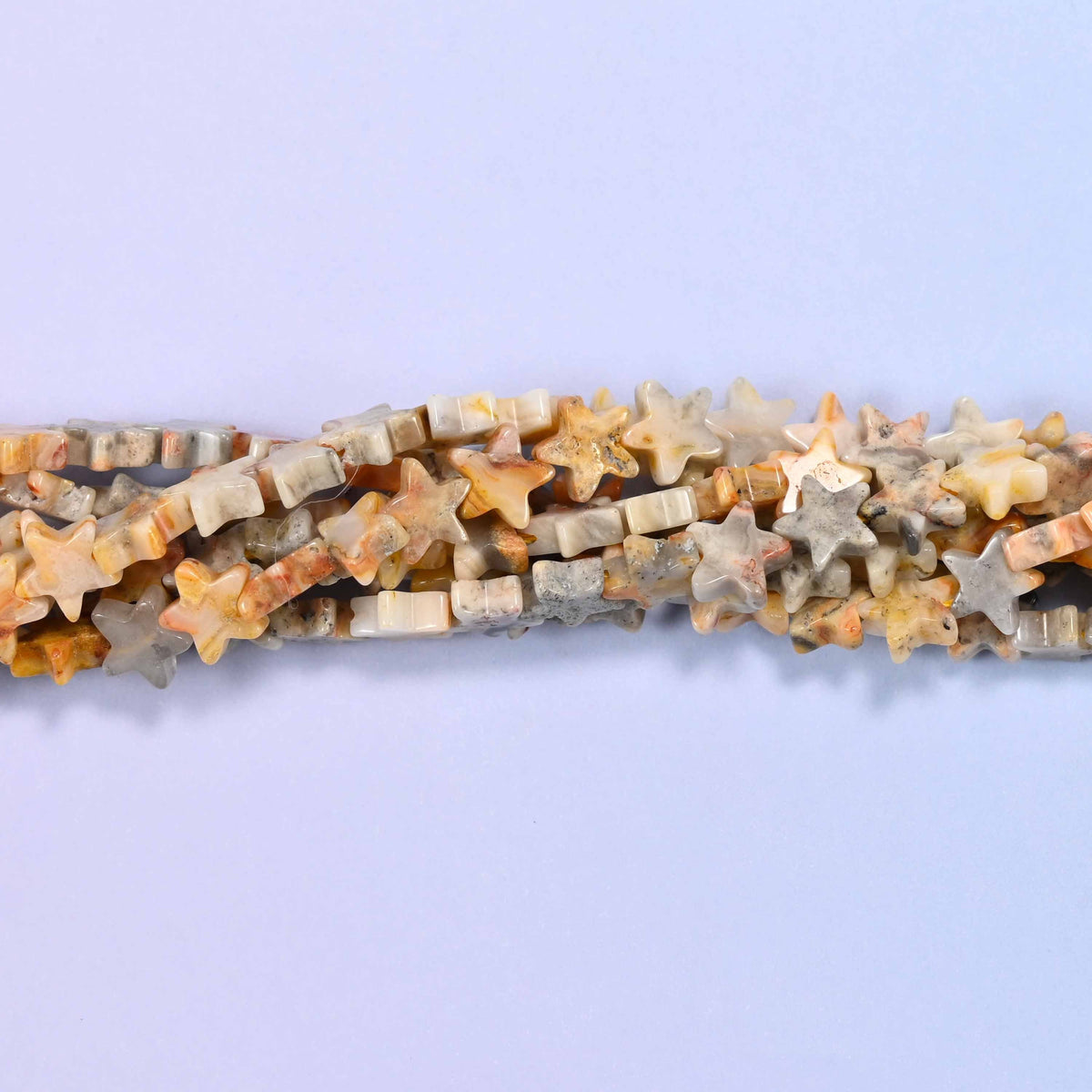 Crazy agate flat star beads in warm cream, apricot, sandy tan and soft grey, each swirled with natural banding.
