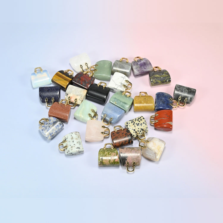 Group of 1 inch purse crystal carvings with gold-tone handles, mini gemstone handbags in rose quartz, tiger eye, jasper, labradorite, sandstone and more