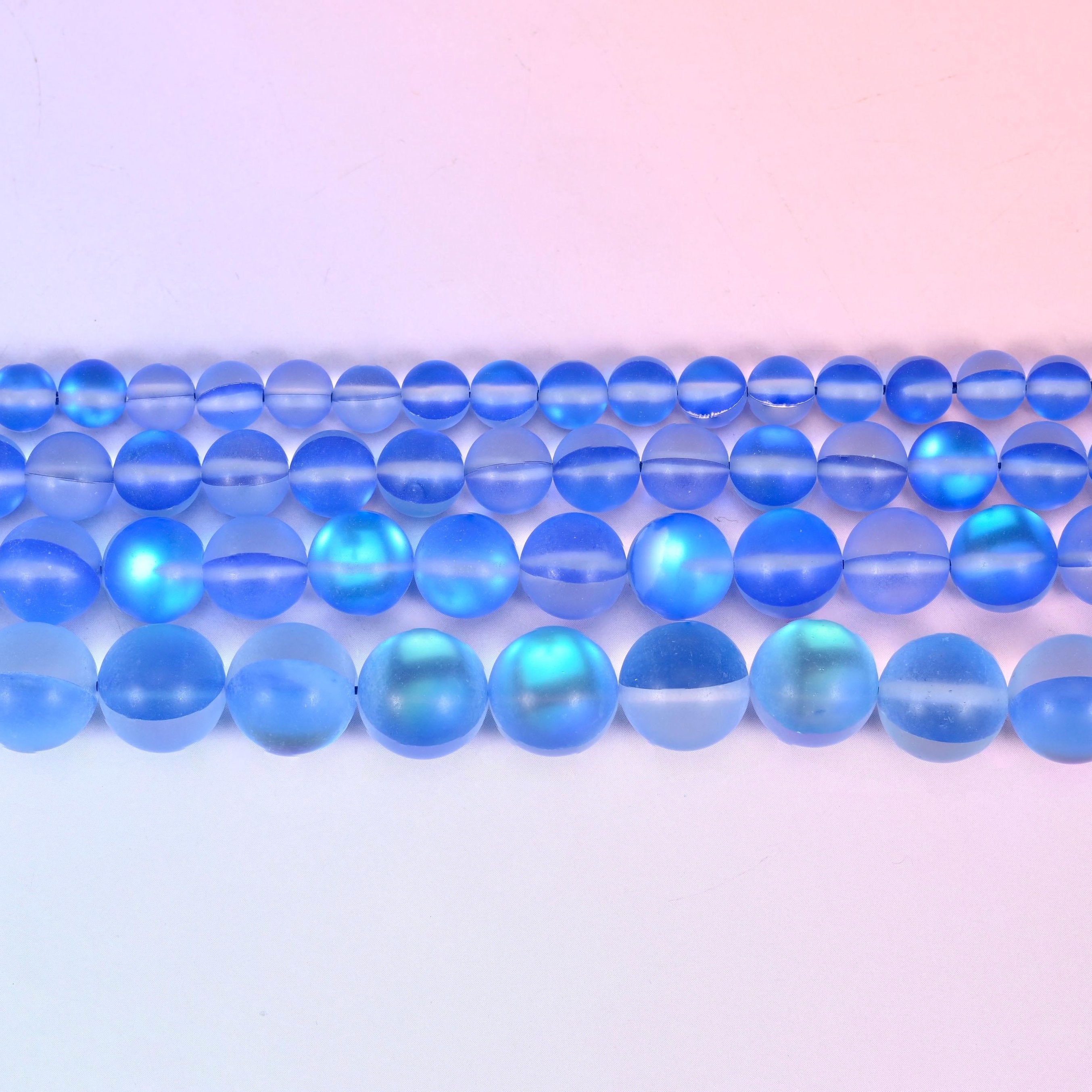 Mystic Aura Matte Blue Round Glass Beads in cornflower blue with a turquoise-and-gold aurora glow