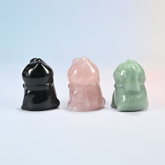 Side view of three gemstone waving cat figurines showing the carved collar and rounded back
