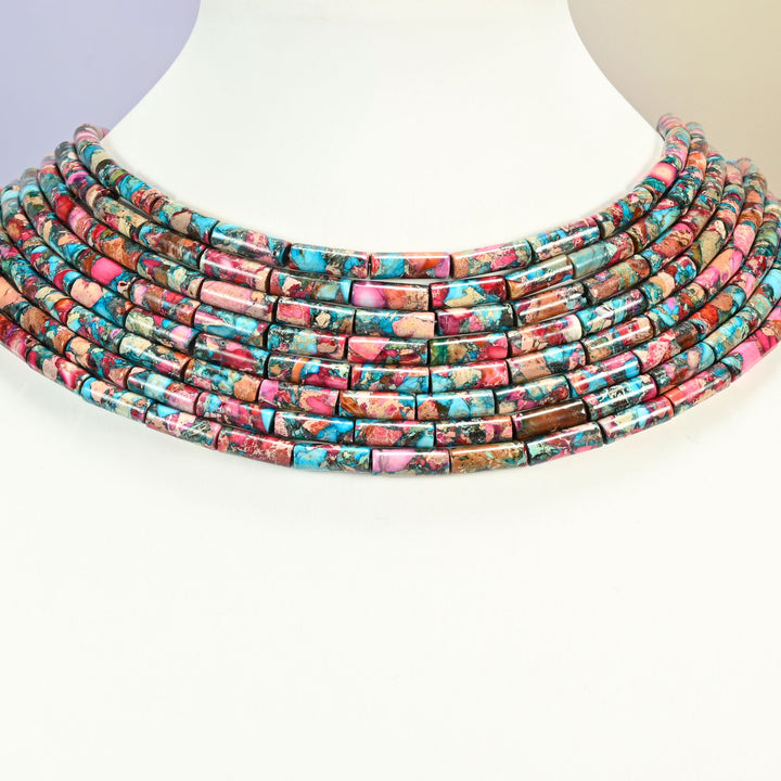 Dyed sea sediment jasper tube bead strands arranged as a layered collar on a white display bust