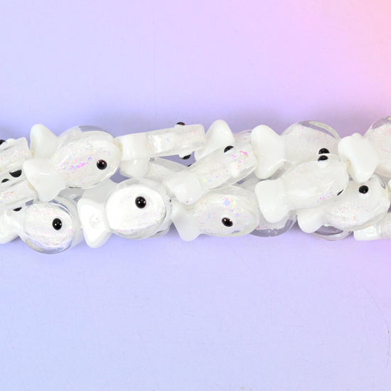 Iridescent White Fish Glass Beads — a milky opal-white fish with a faint pearl shimmer running across its body, a translucent flared tail and a small black eye dot.
