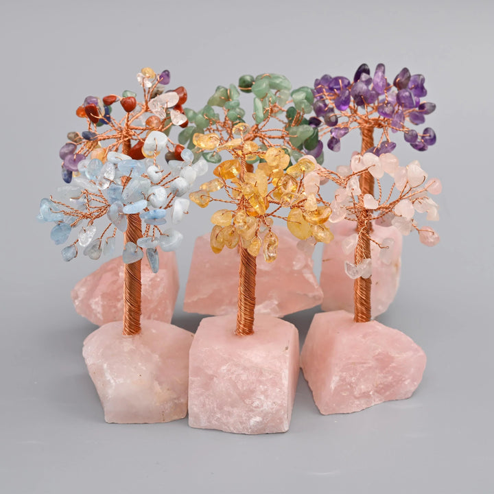 4 inch rose quartz gemstone tree with a copper wire trunk on a rough-cut rose quartz base