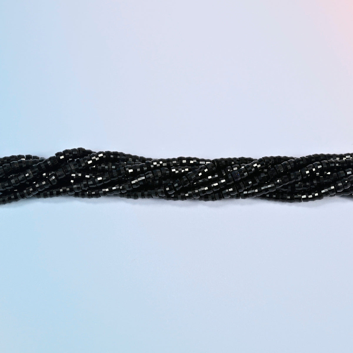 Strands of black onyx faceted heishi disc beads twisted together in a horizontal row