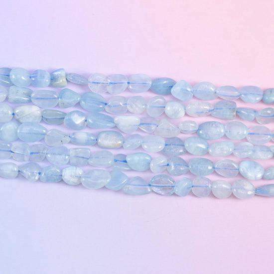 Close row of smooth polished aquamarine nuggets in milky sky blue and white