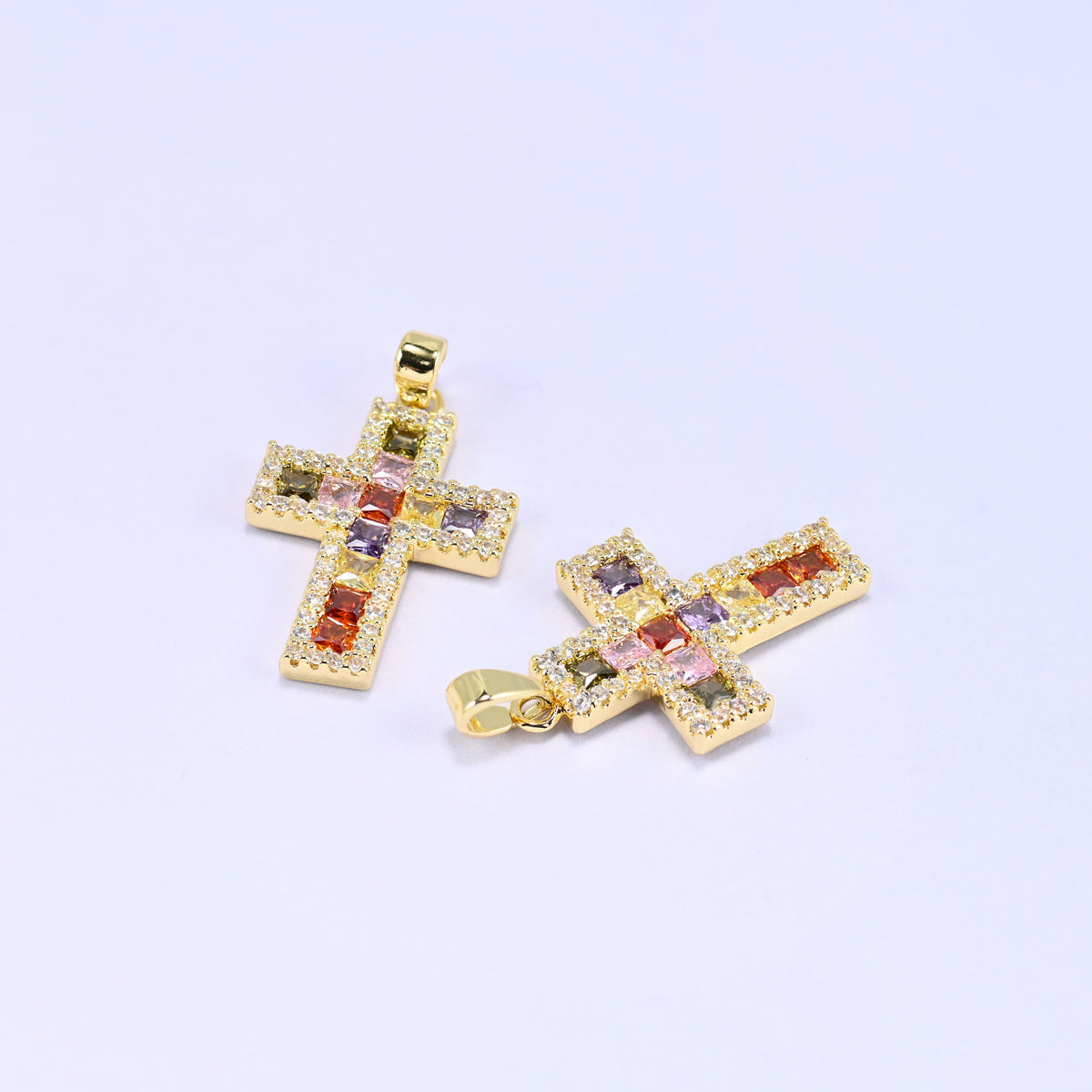 Zirconia cross charms, two gold plated pendants angled to show the depth of the setting