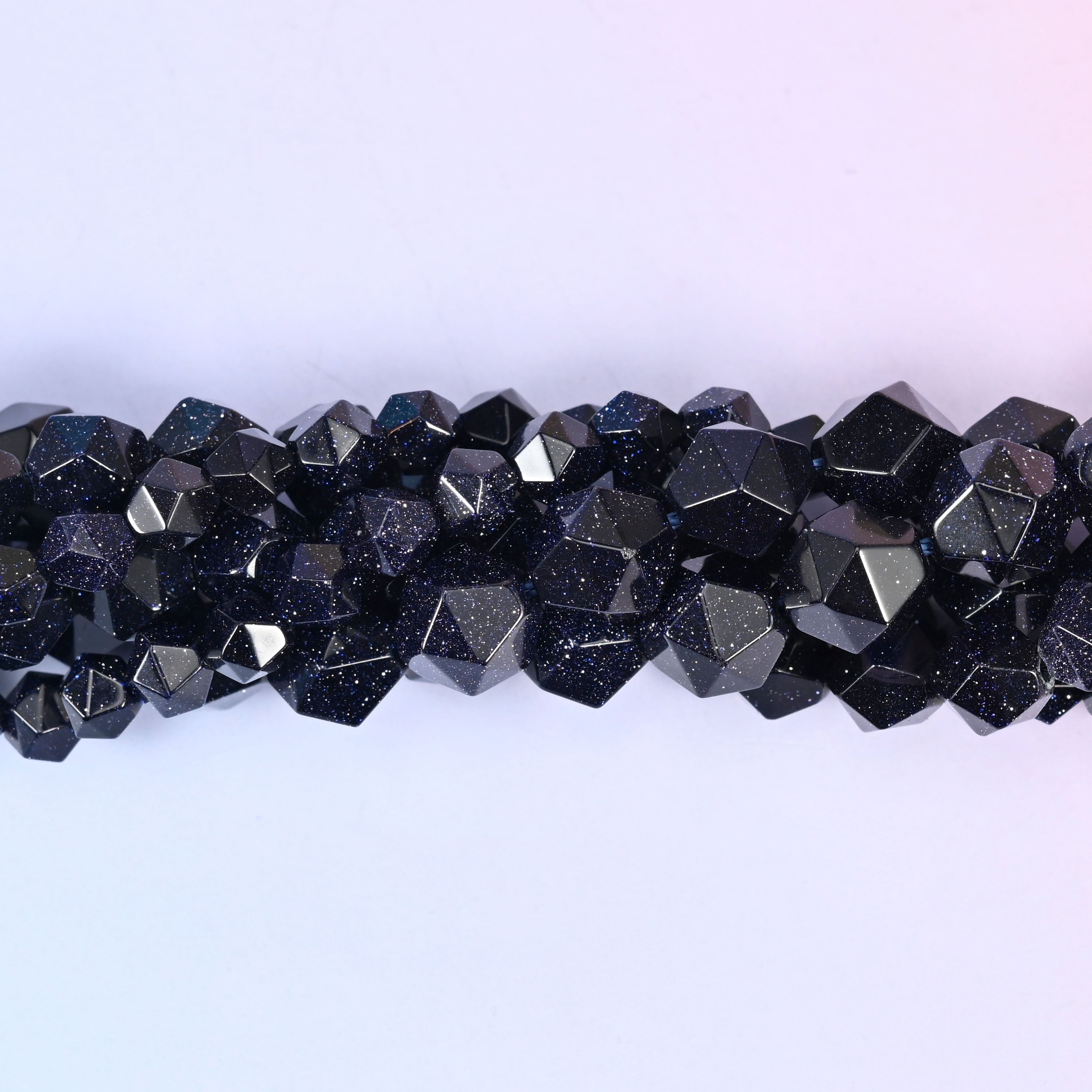 Close-up band of blue sandstone beads where the fine copper glitter flecks catch the light