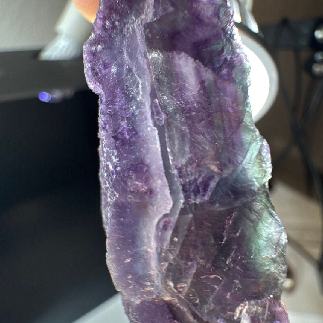 Backlit view where green and lilac layers glow through the purple fluorite