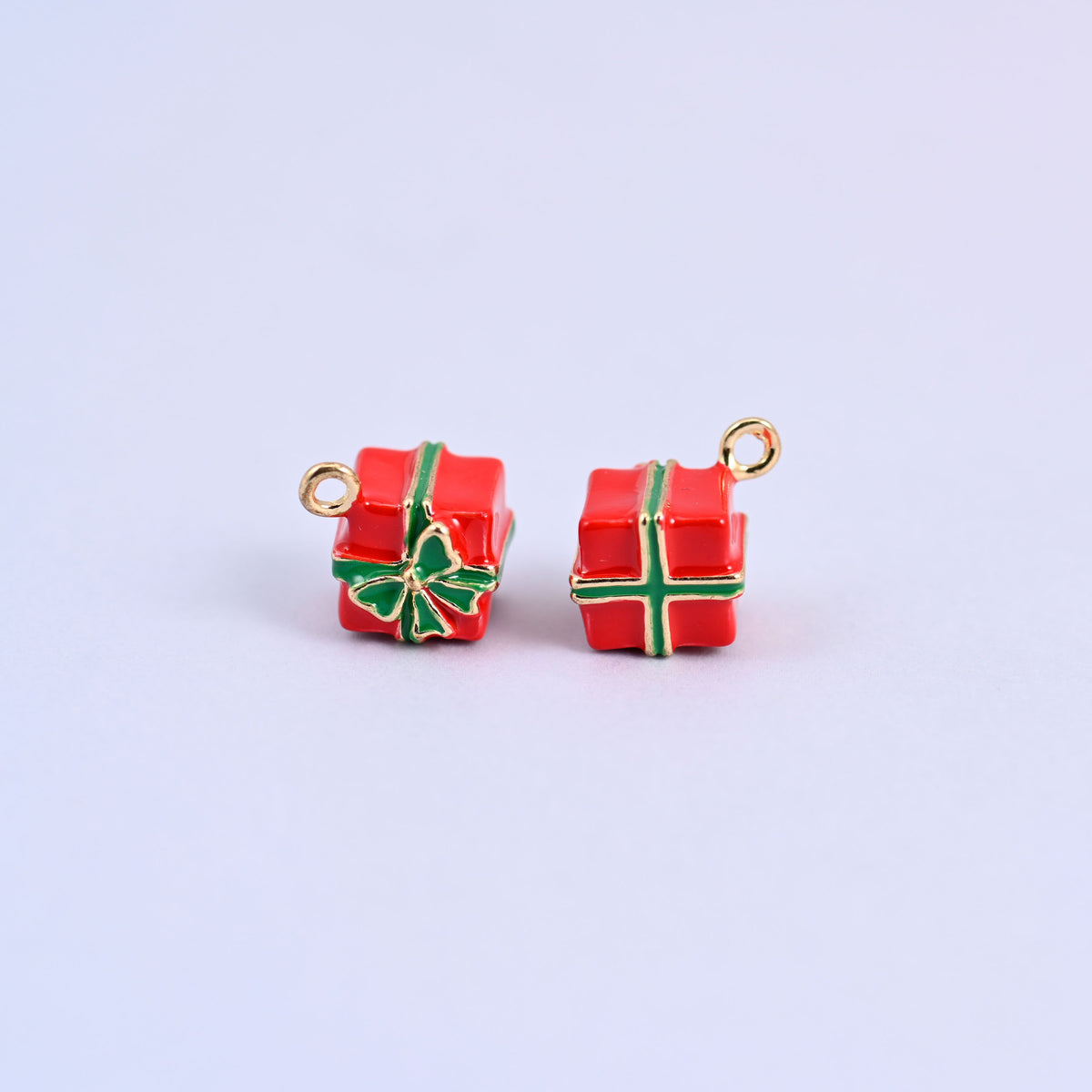 Two red gift box charms with green enamel ribbon and bow, front and back.