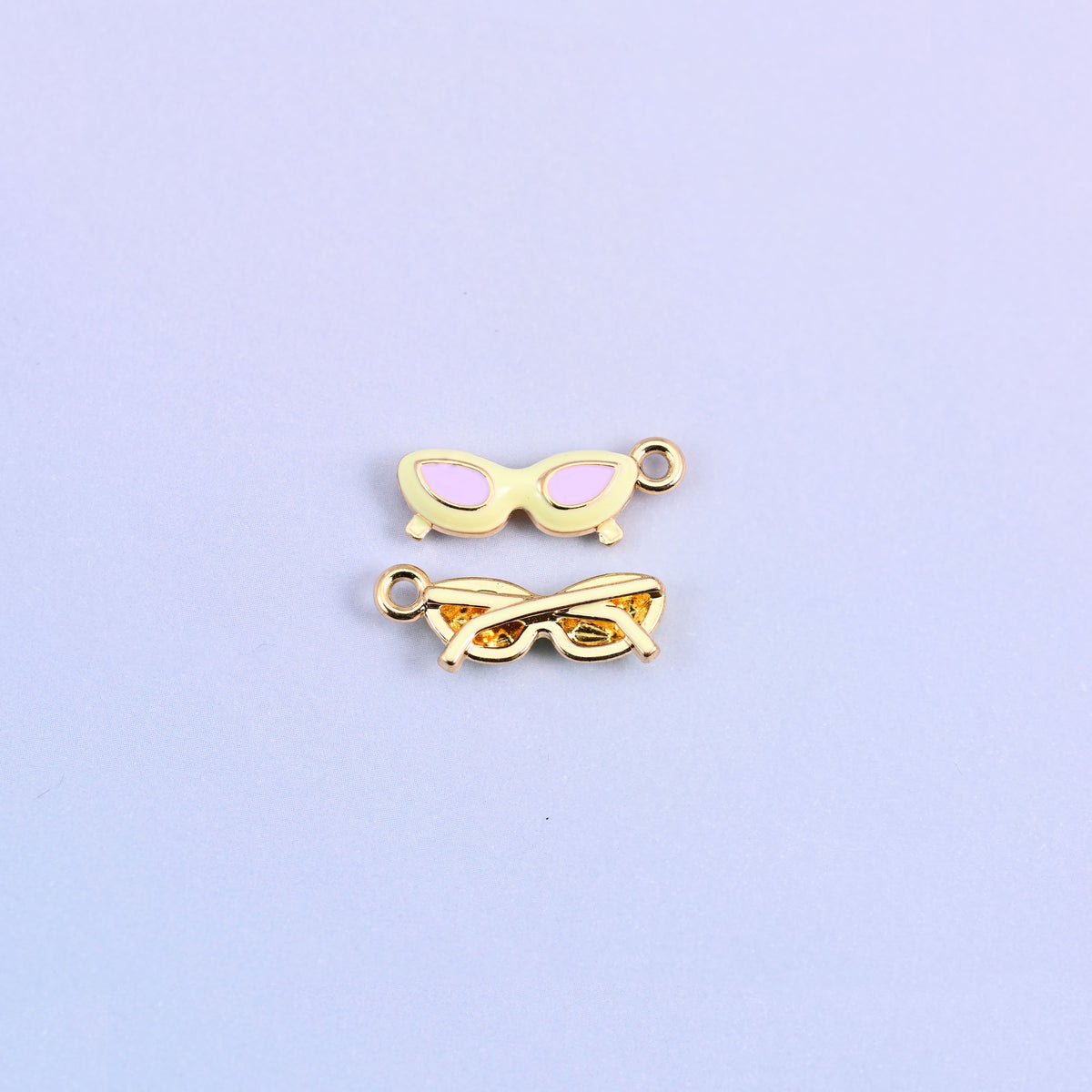 Light yellow cat eye sunglasses charm with pink lenses, front and back.