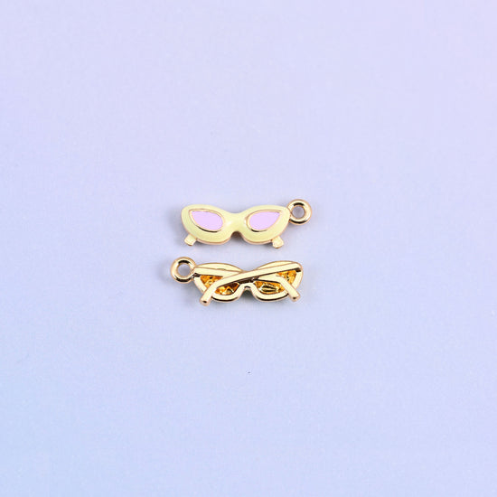Light yellow cat eye sunglasses charm with pink lenses, front and back.