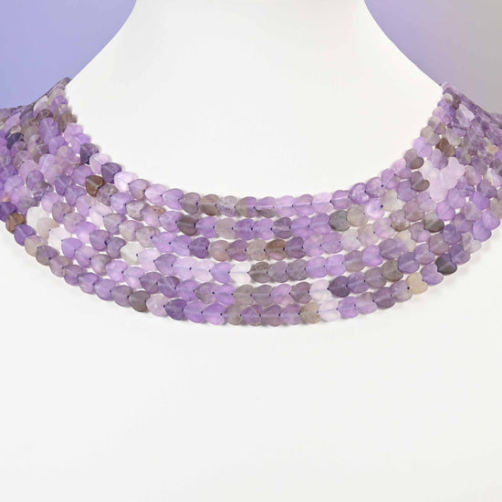 Close-up of Amethyst flat heart-shaped beads showing natural purple and lavender color variation across the strand