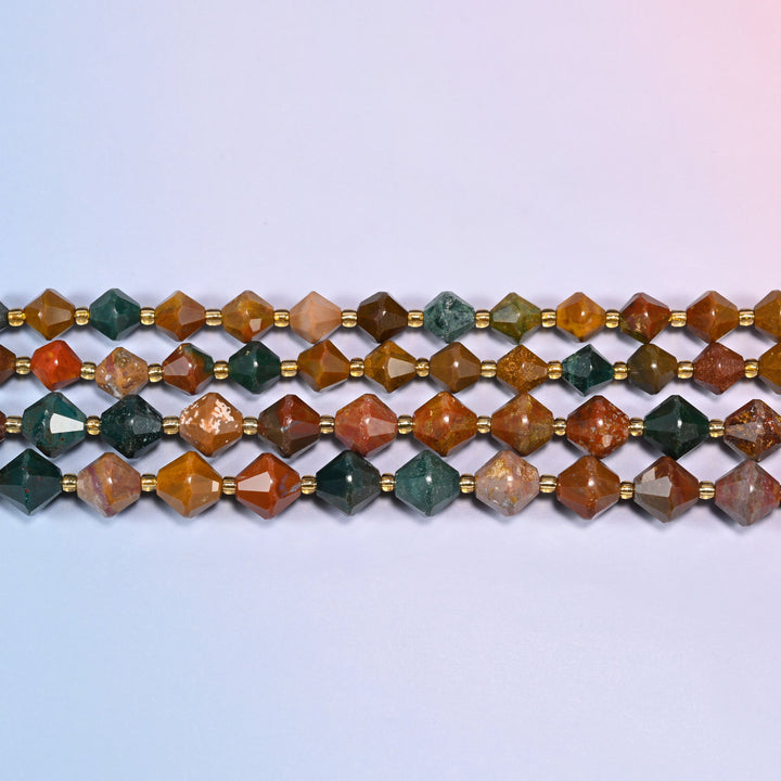 Rows of ocean agate faceted bicone beads laid straight across a lavender backdrop, a gold glass spacer between every bead.