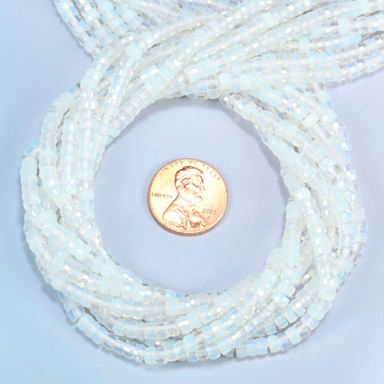 Opalite faceted heishi disc beads 2x4mm coiled in a loop around a US penny for scale, close-up of the faceted disc shape