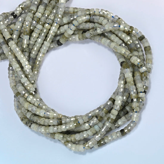 White labradorite faceted heishi disc beads coiled into overlapping loops, whole strands of soft gray-green stone