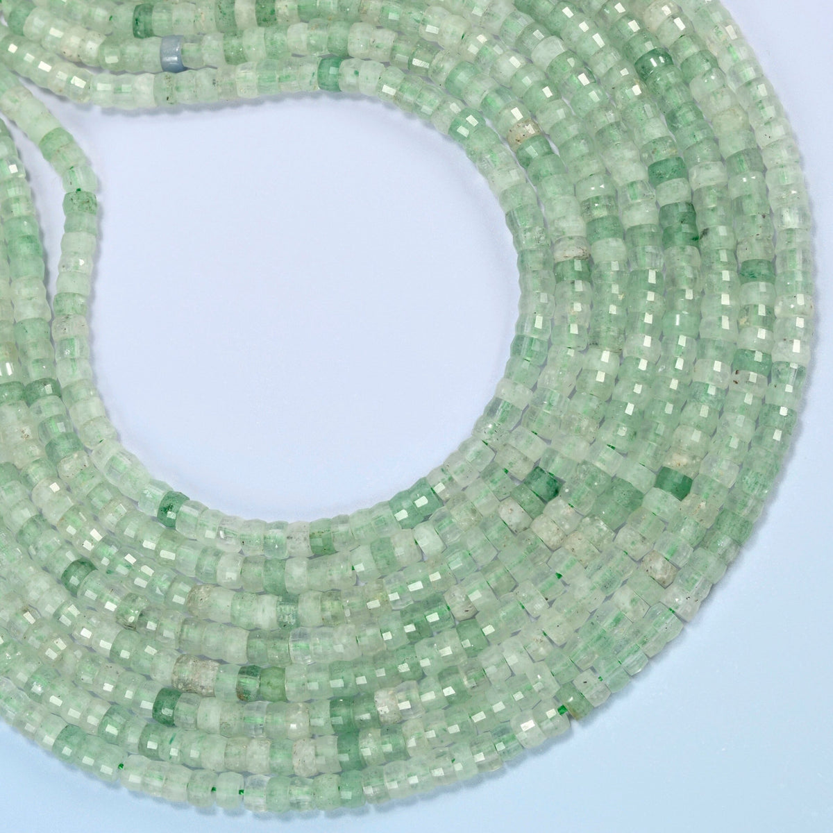 Green strawberry quartz faceted heishi disc beads curved into an open loop, light green beads with darker flecks