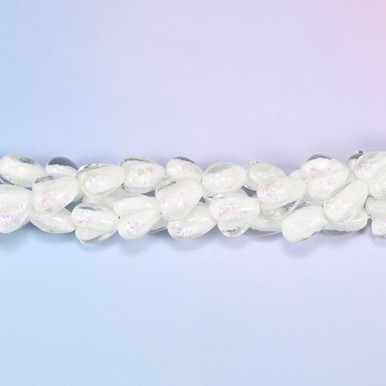 Milky opaque white glass hearts carrying a soft pearly iridescence, closer to freshwater pearl than plain white glass