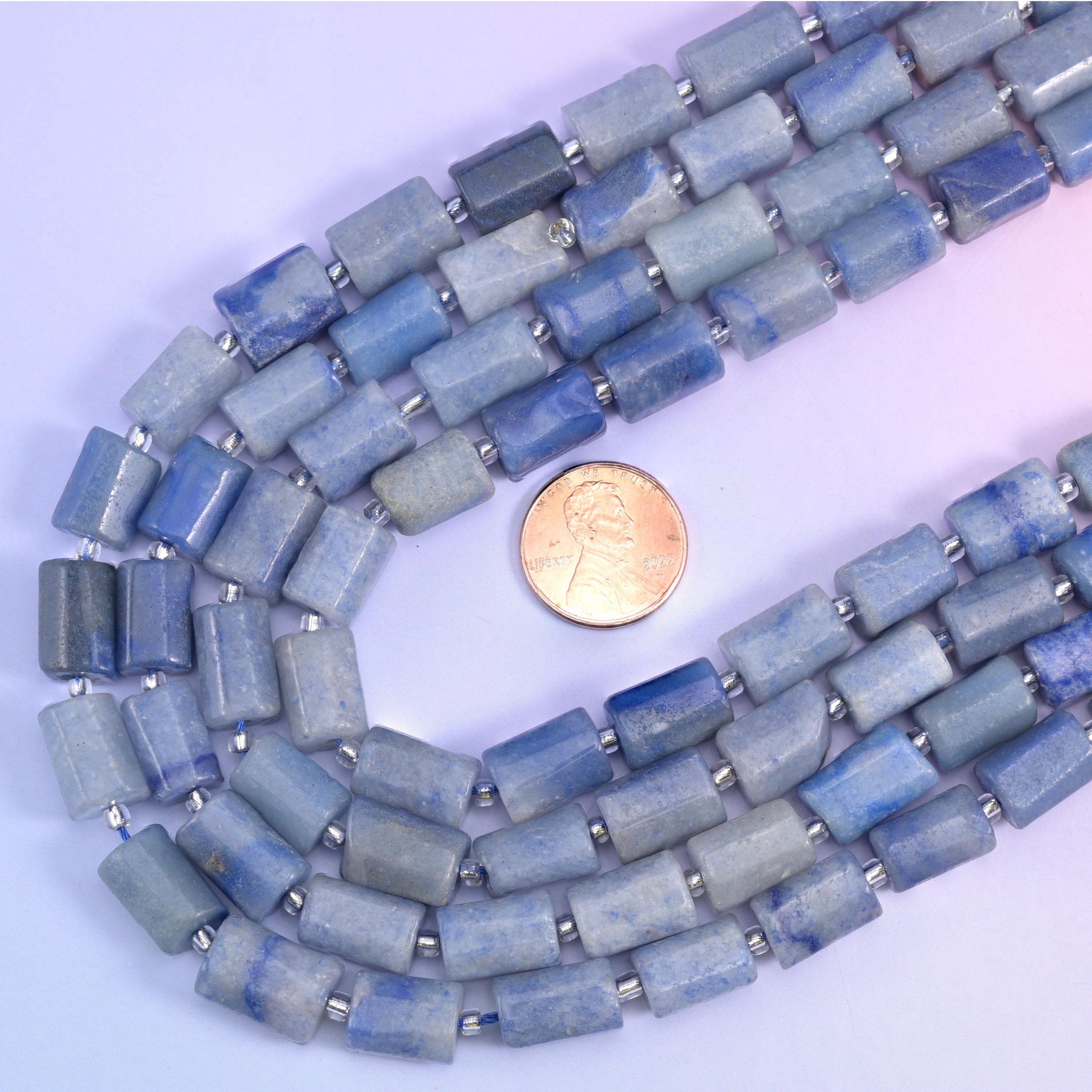 US penny inside a looped strand of blue aventurine tubes, showing the 12x8mm bead size
