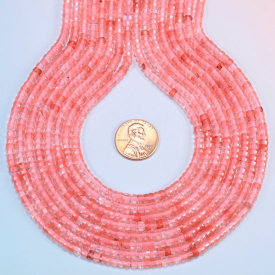 Melon quartz faceted heishi disc strands formed into a teardrop loop around a US penny for scale