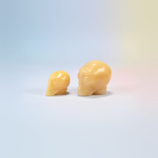 Two yellow jade alien head crystal carvings, 1.5 inch and 2 inch, honey yellow natural stone