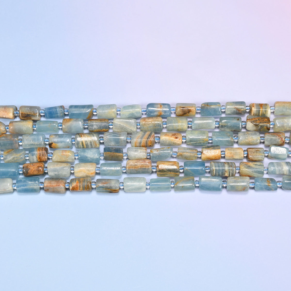 Blue calcite faceted tube beads in straight rows, small blue spacers set between the tubes.