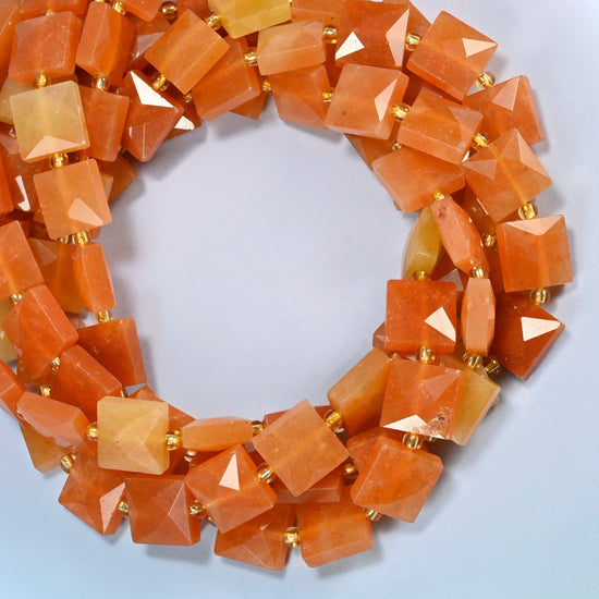 Natural red aventurine faceted flat square beads coiled into overlapping loops, whole strands of warm orange-red stone