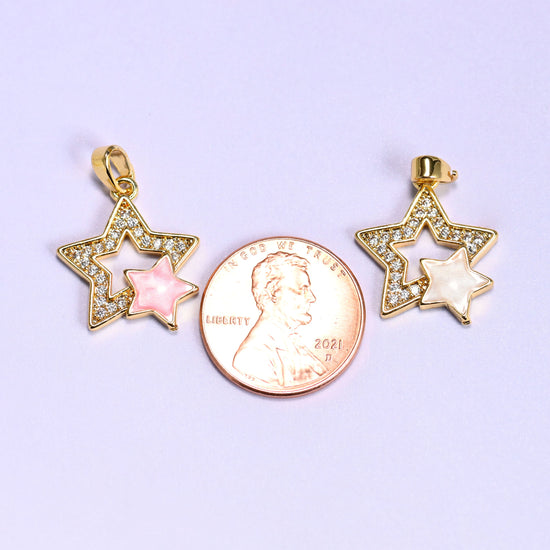 Double Stars Zirconia Charms shown with a US penny for scale, the pink and white pendants sitting either side of the coin at close to its width.