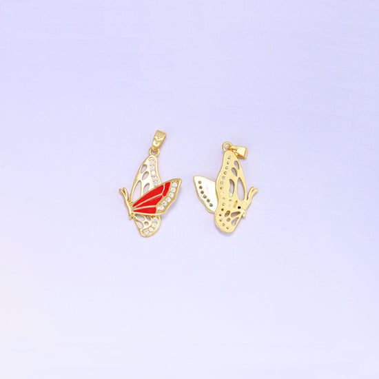 Flying butterfly charm pendant front and back, the red enamel and zirconia face beside the open filigree gold reverse of a second charm.