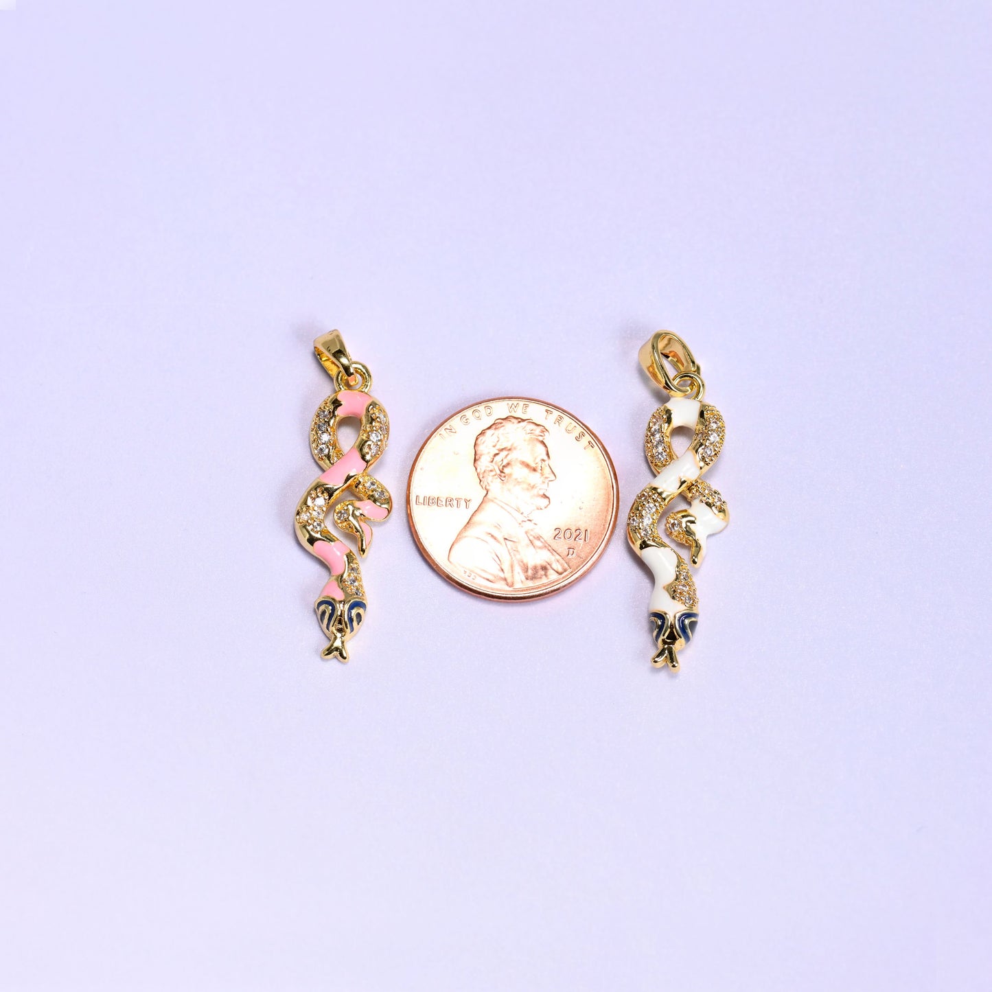 Enamel Snake Zirconia Charms photographed either side of a US penny, the pink and white coiled pendants clearly longer than the coin.