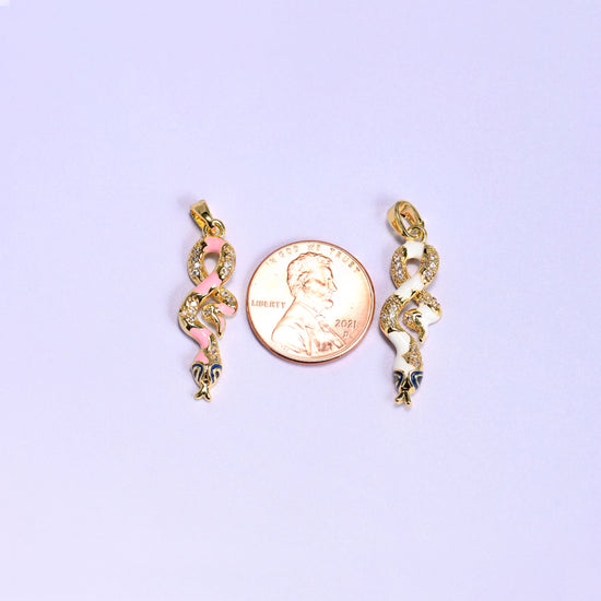 Enamel Snake Zirconia Charms photographed either side of a US penny, the pink and white coiled pendants clearly longer than the coin.