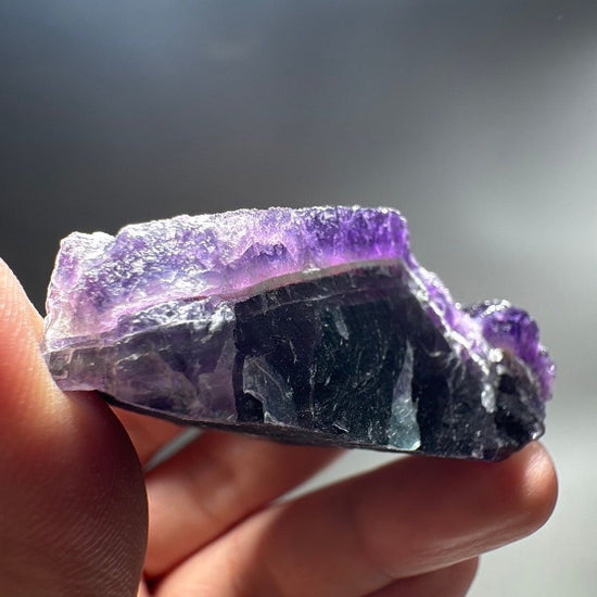 Side view of 3.4 oz fluorite specimen with deep green fluorite band beneath purple crystal.