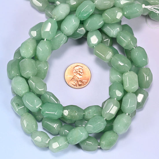 Close-up horizontal row of green faceted Aventurine barrel beads laid straight, showing the polished facet detail up close.