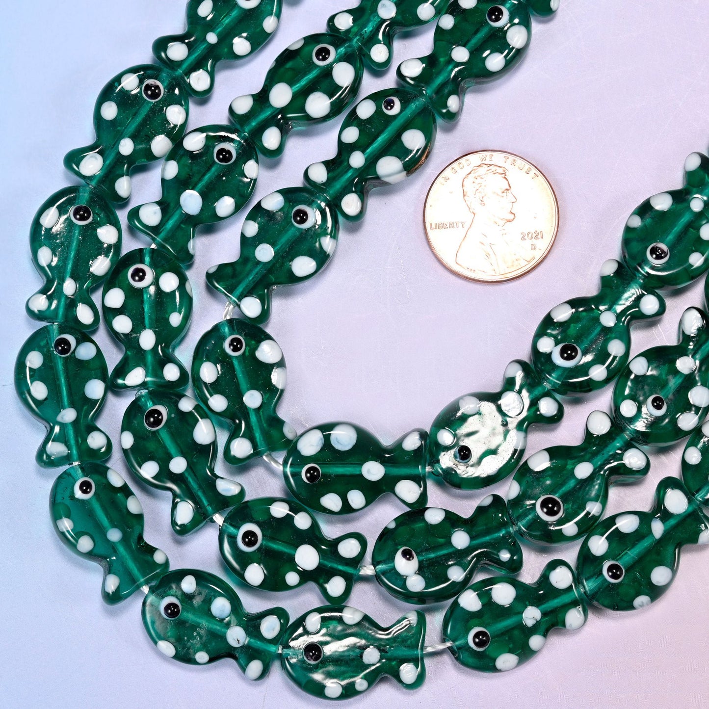 Fish-shaped jungle green glass beads with white dot pattern