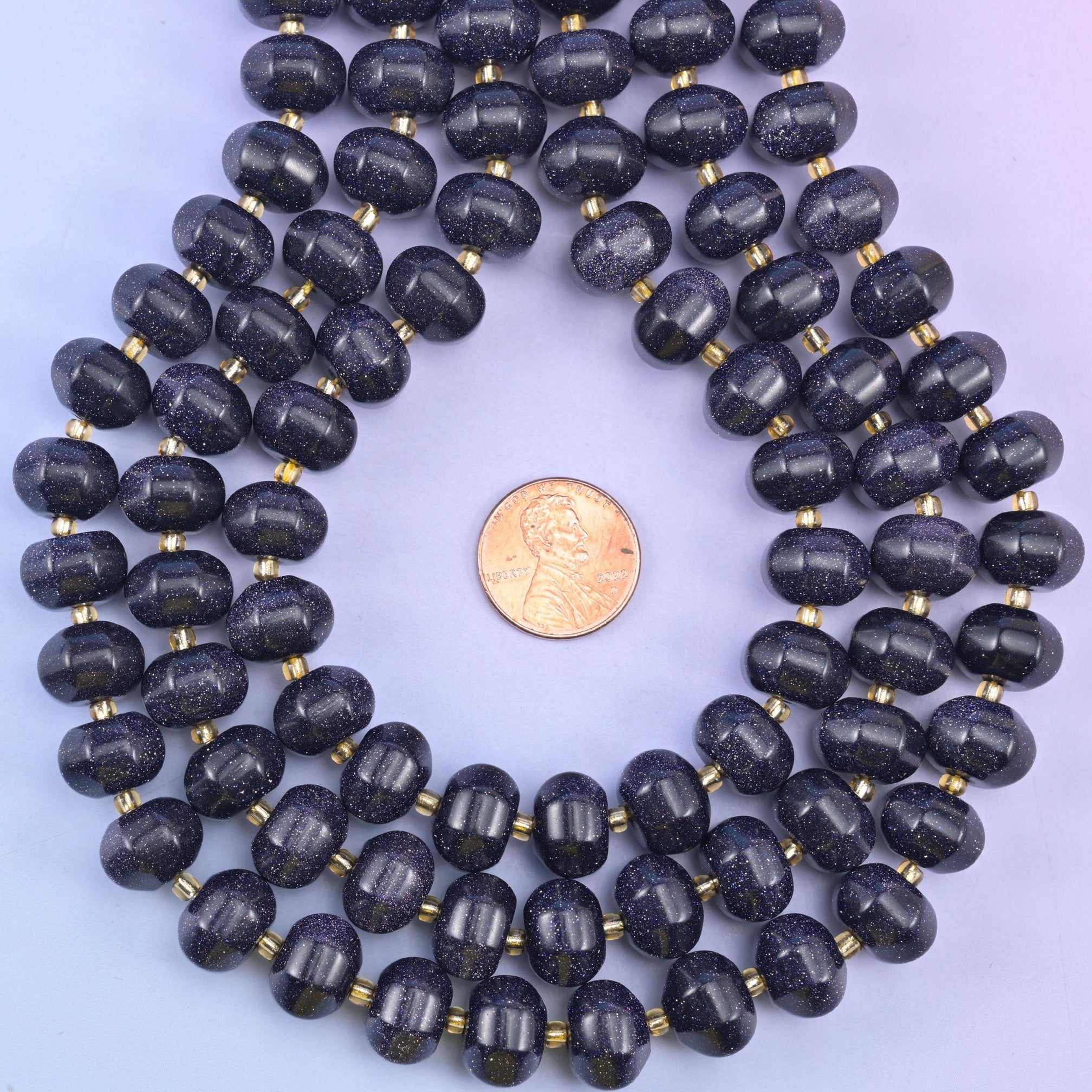 Blue Sandstone pumpkin bead loop framing a penny to show the bead scale